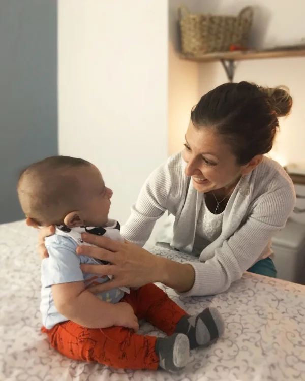 Alison playing with a smiling baby.