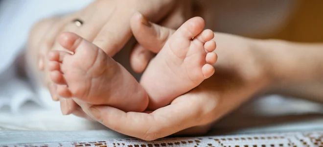 Hands holding baby feet.